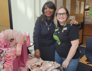 Two people standing close to each other near a table of fashion accessories