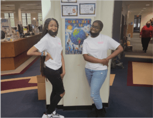 Two people standing near a poster